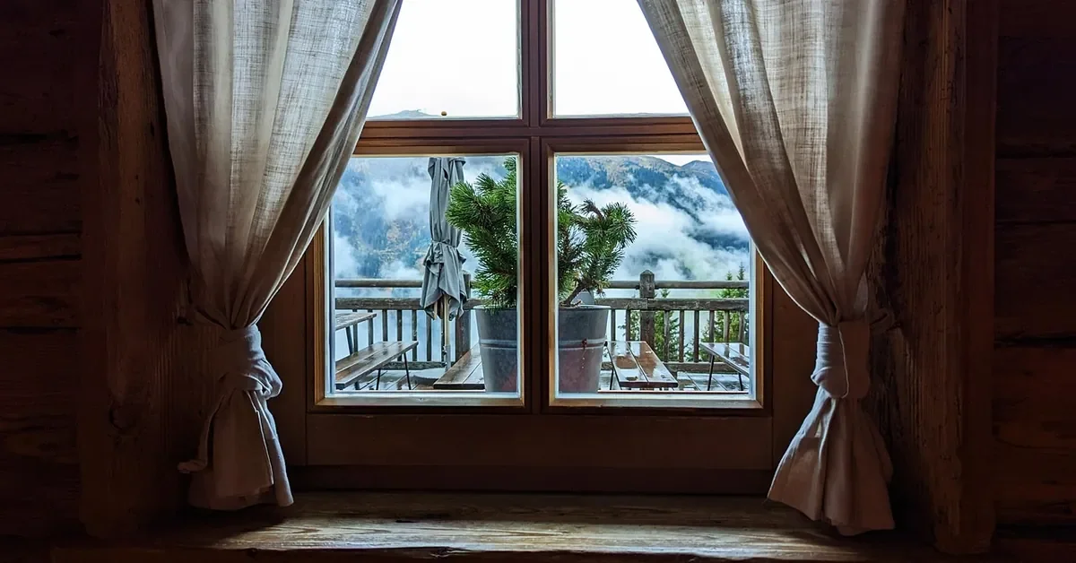 Wood-framed divided-light window in a timber room