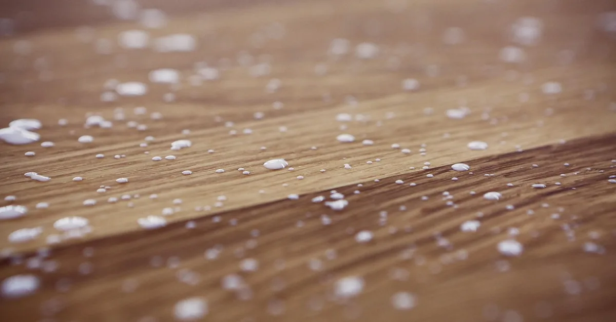 Beads of wood glue on a raw wooden board surface