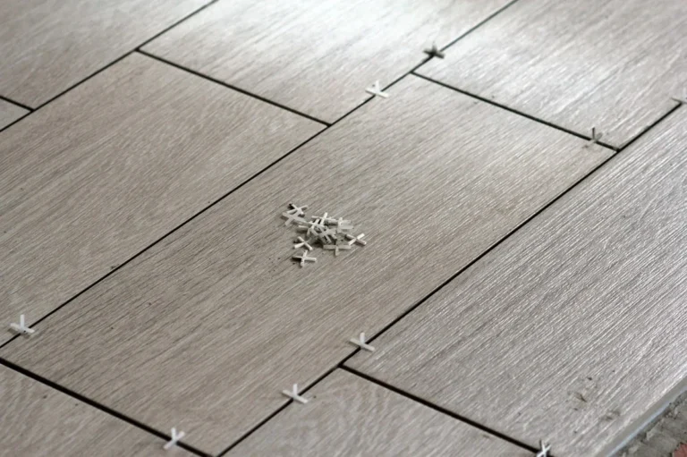 Ceramic tile being set into thinset over a subfloor during installation