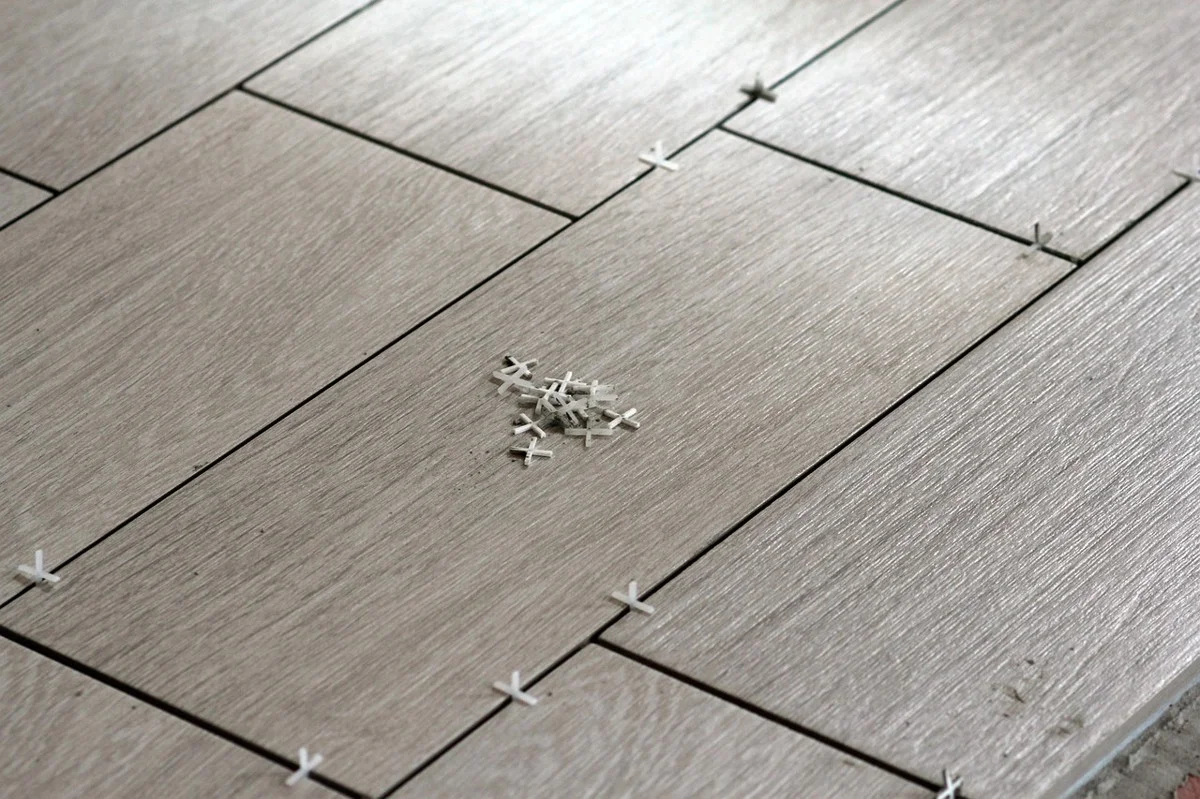 Ceramic tile being set into thinset over a subfloor during installation