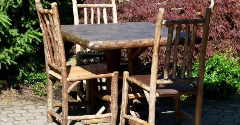 rustic unfinished wood table and chairs made from raw log branches outdoors