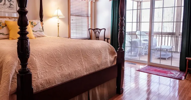 Four-poster bed on a glossy hardwood floor in a bedroom