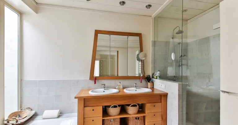 Cedar-toned wood bathroom vanity beside a glass-enclosed shower stall