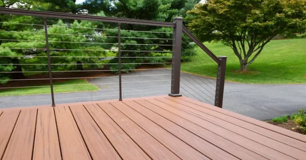 Composite deck with cable railing showing the material's natural wood-look grain