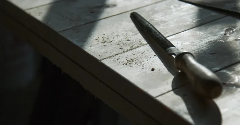 Hand saw and wood file resting on baseboard trim, cut without a miter saw