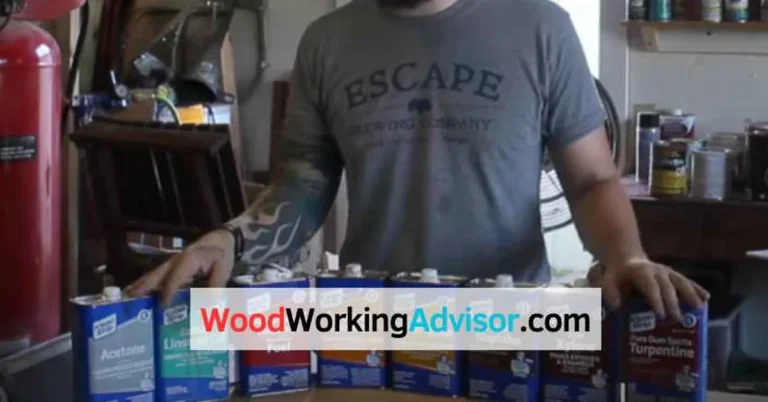 assorted solvent cans including denatured alcohol and mineral spirits arranged on a woodworking workshop bench