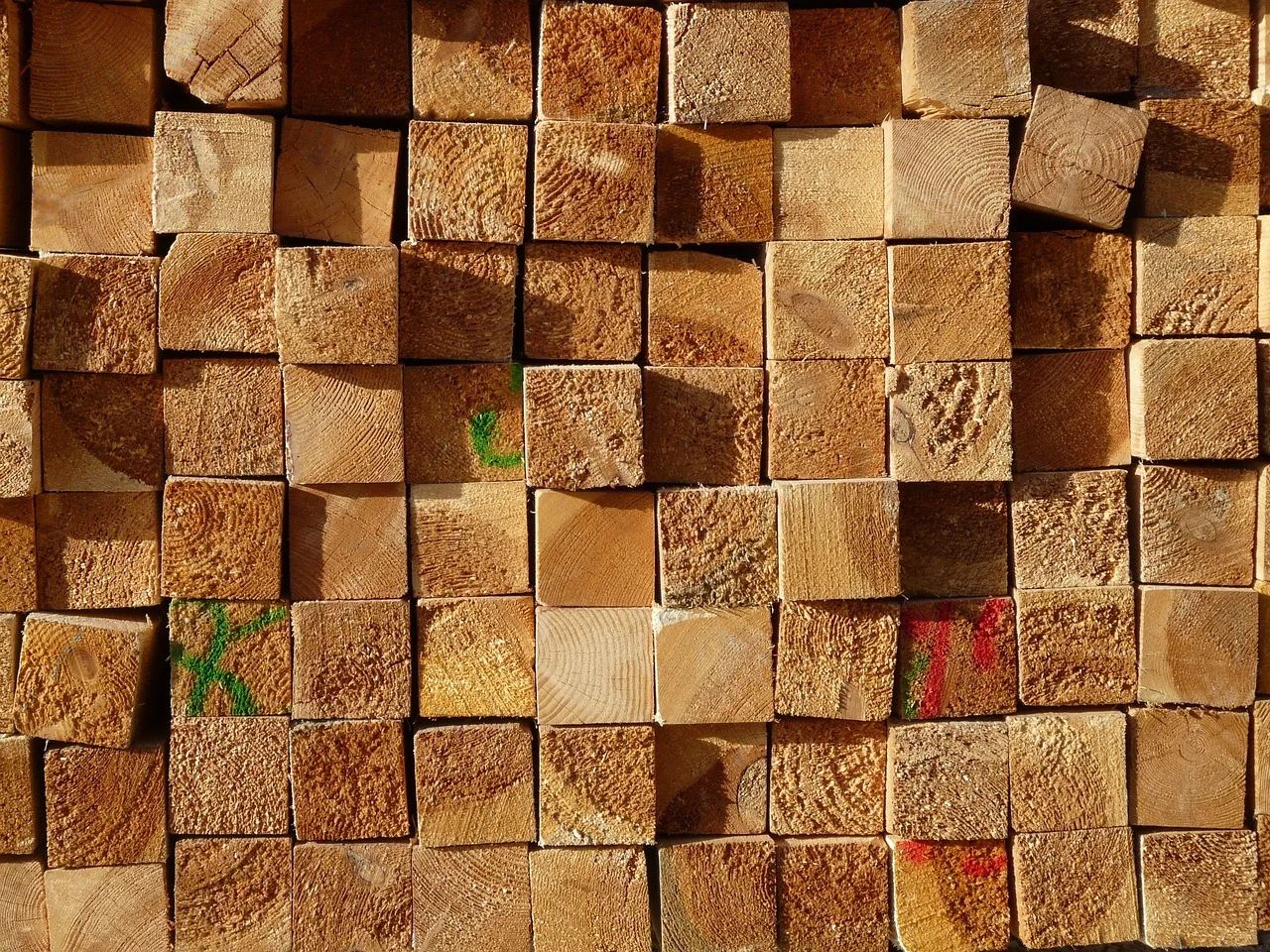 stack of sawn softwood framing lumber showing end-grain growth rings at a lumber yard