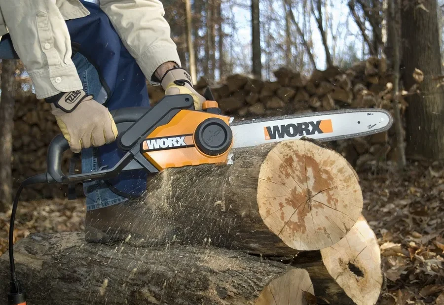 Corded electric chainsaw cutting a log, no engine and no fuel mix needed