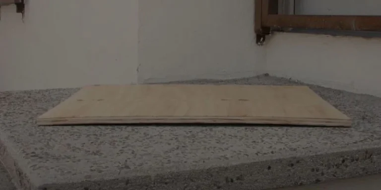 Warped plywood sheet with a visible bow, ready to be flattened