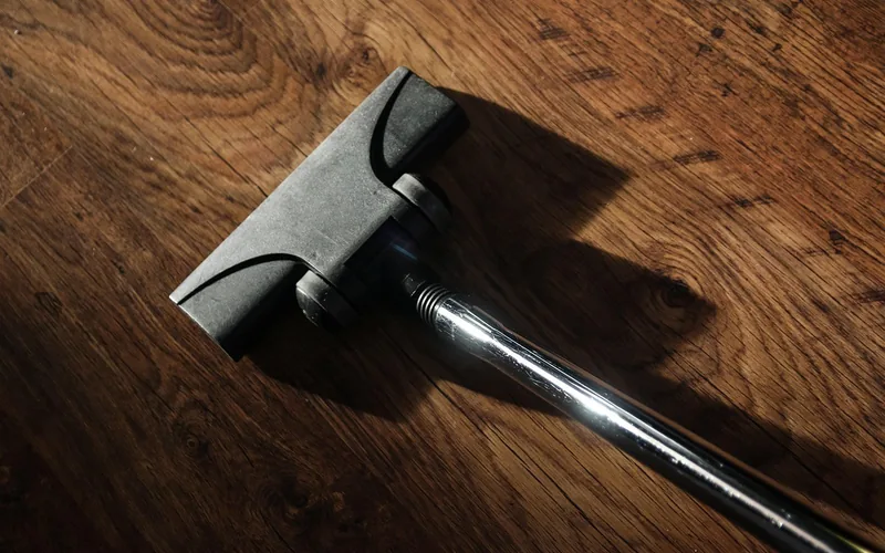 Vacuum cleaner head on a dark wood floor Vacuum cleaner head on a dark wood floor