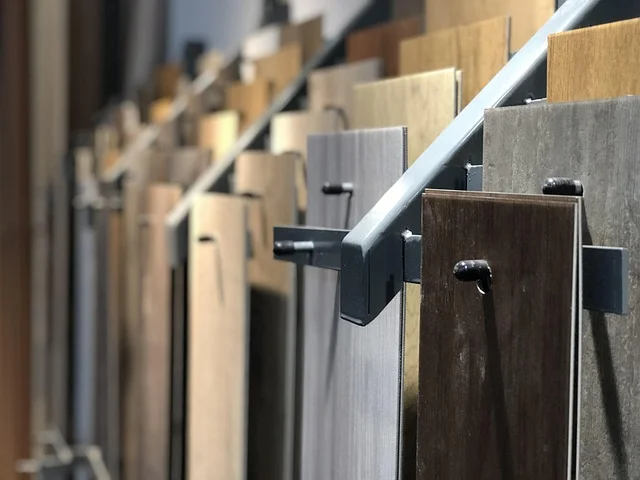 Rows of laminate flooring plank samples in different wood tones on a showroom display rack