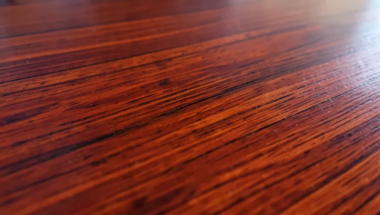 Genuine mahogany shows a deep reddish-brown color and straight, fine grain