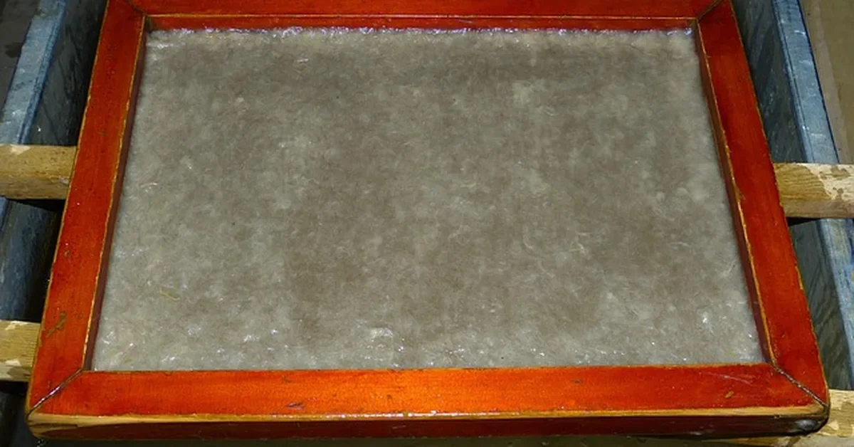wooden mould and deckle dipped in sawdust paper pulp