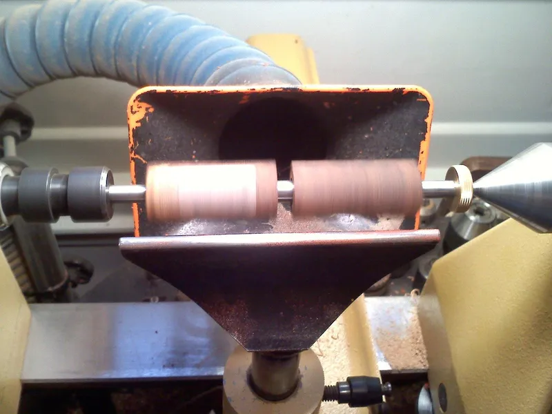Wood pen blanks mounted on a mini lathe during turning, ready for a CA glue finish Wood pen blanks mounted on a mini lathe during turning, ready for a CA glue finish