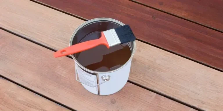 Applying wood stain with a brush to a wood panel