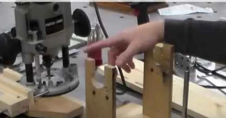 Porter Cable plunge router with edge guide attached, routing a slot in a workpiece clamped to a workbench
