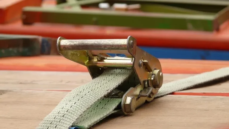 Ratchet strap tensioned over a load of boards