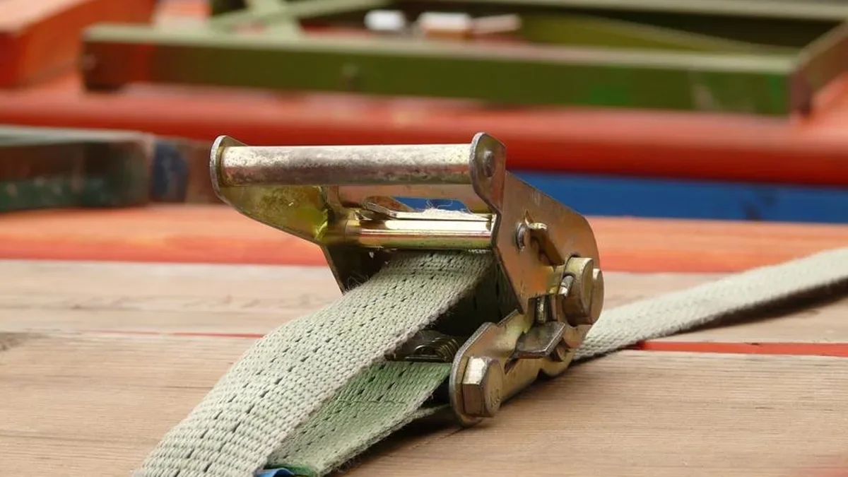 Ratchet strap tensioned over a load of boards