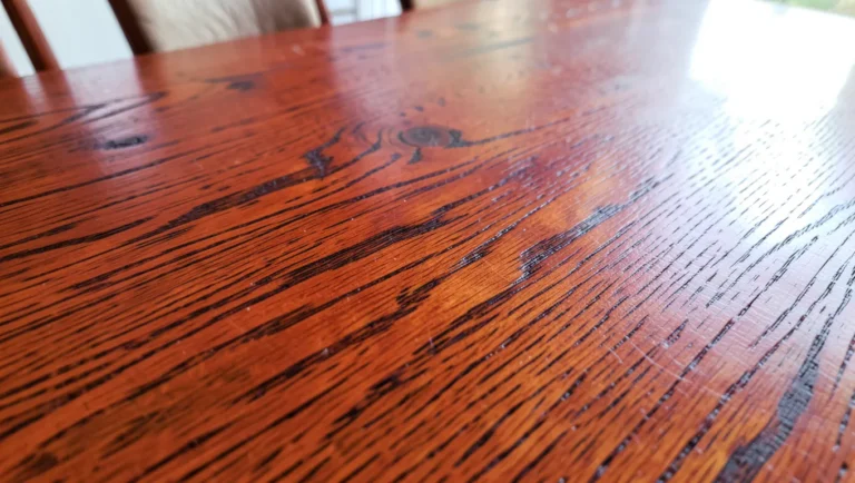 Close-up of red oak wood furniture surface showing its warm color and open grain