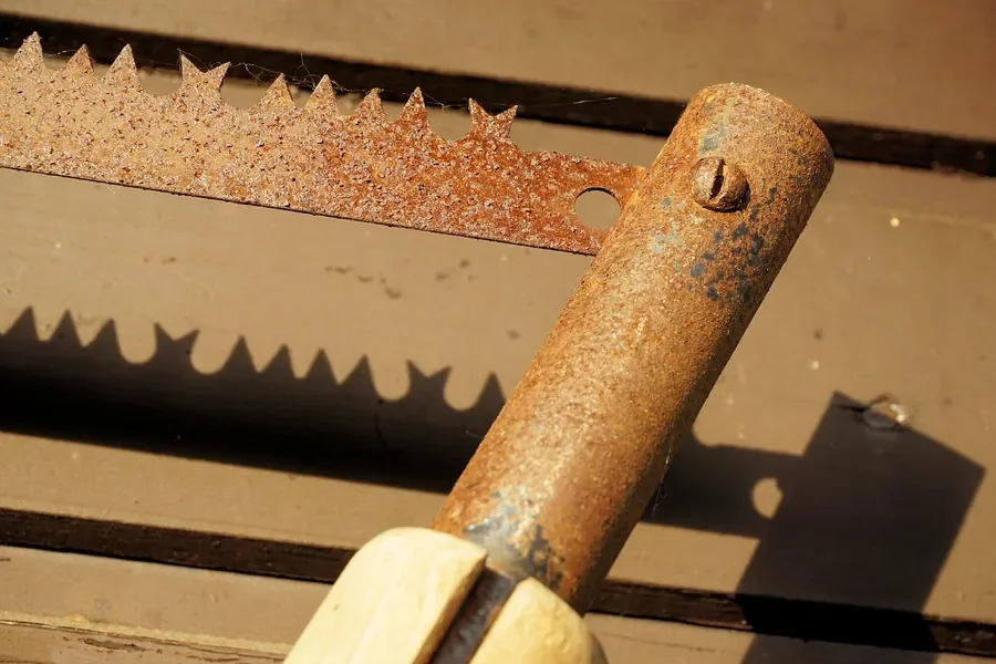 Close-up of an old saw blade and metal collar covered in orange rust