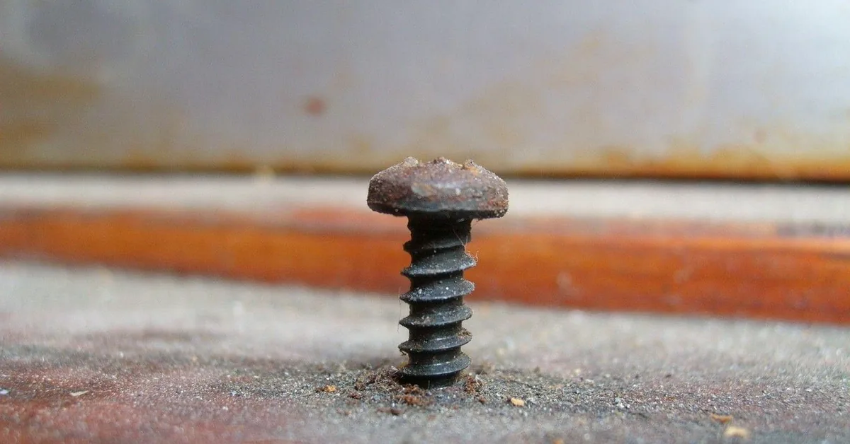 Rusted screw stuck in a metal surface