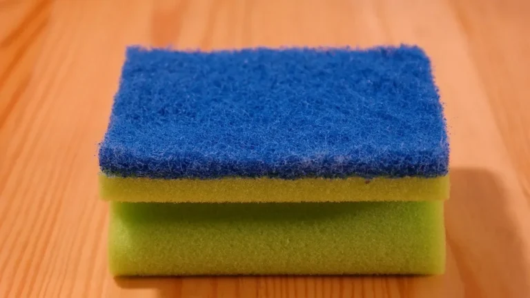 Scouring sponge resting on a finished wood surface