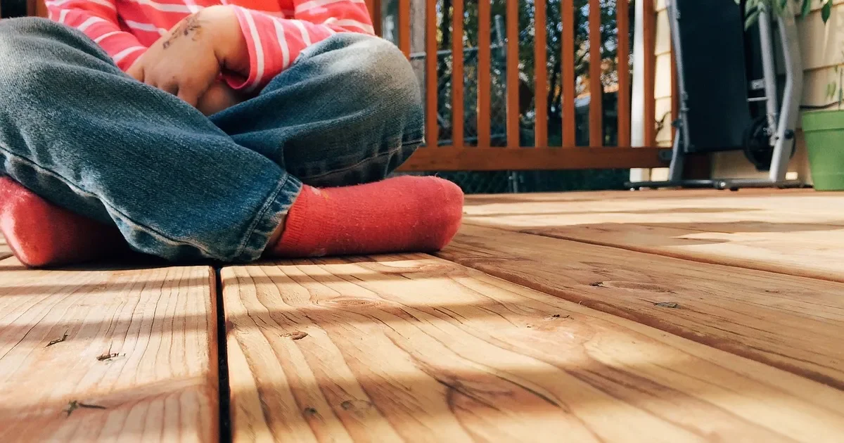 Sunlit wood deck boards and railing on a backyard deck
