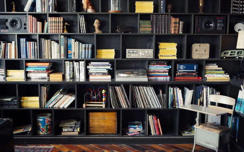 wall-mounted wood shelving packed with books, showing typical book storage density wall-mounted wood shelving packed with books, showing typical book storage density