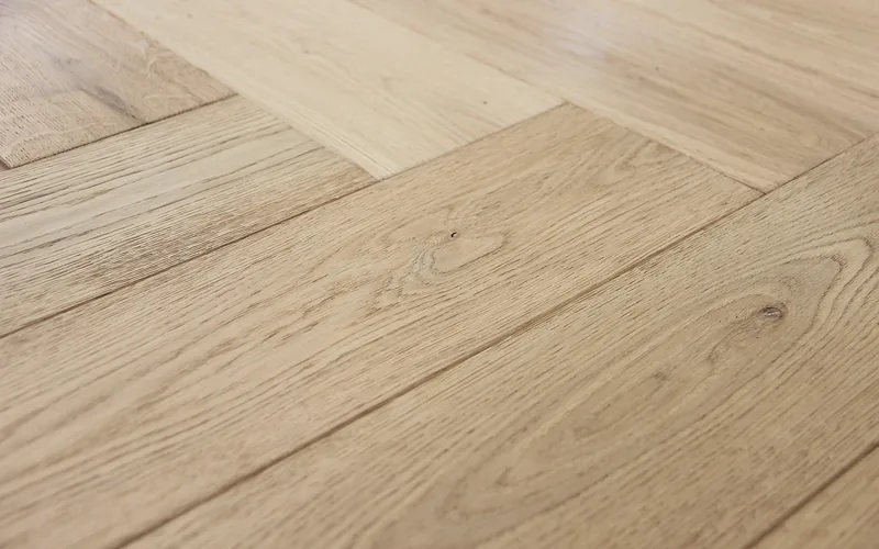 Herringbone-pattern oak hardwood floor showing a custom parquet layout