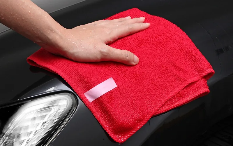 wiping wood stain overspray off car paint with microfiber cloth