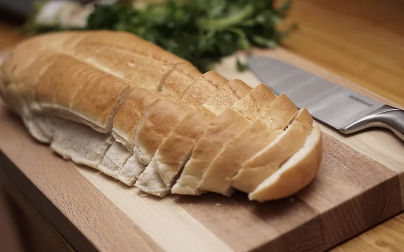 wood cutting board on a kitchen counter with sliced bread