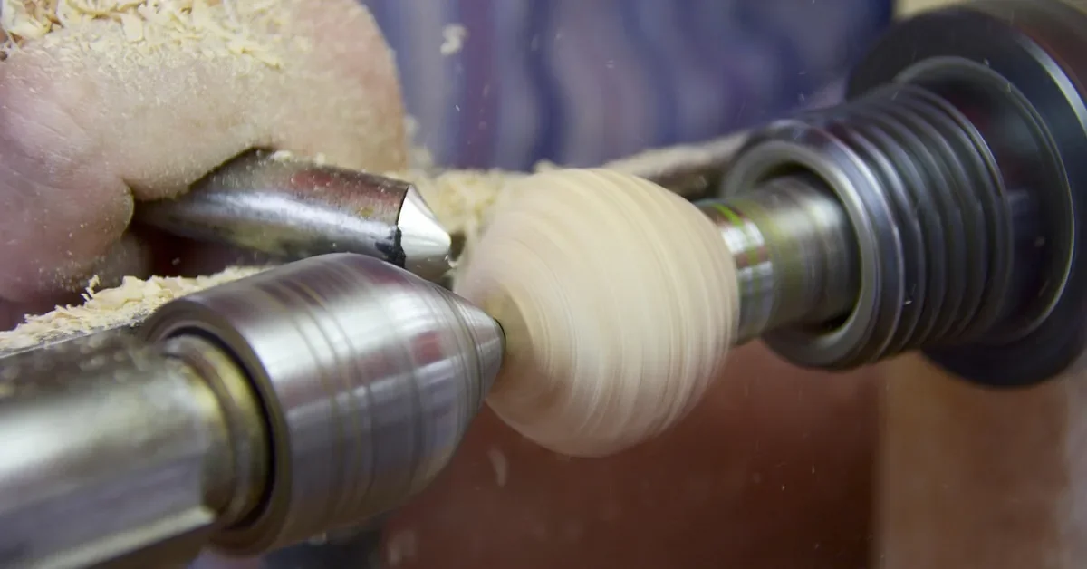 Spinning wooden blank on a lathe with a turning tool at the tool rest