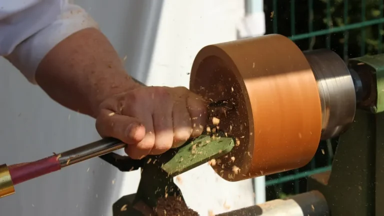 Turner shaping a wood blank on a lathe with the tool rest close to the workpiece