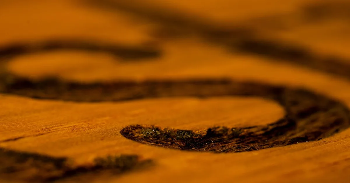 close-up of dark wood stain finish soaking into carved wood grain