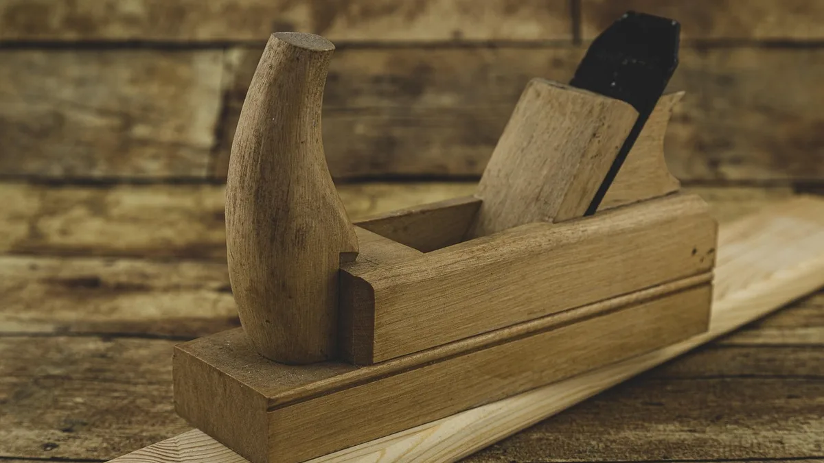 Wooden hand plane resting on a plank used for chamfering an edge