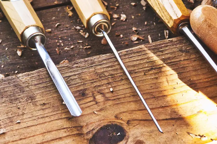 Wood carving chisels laid out on a workbench, general woodworking hand tools
