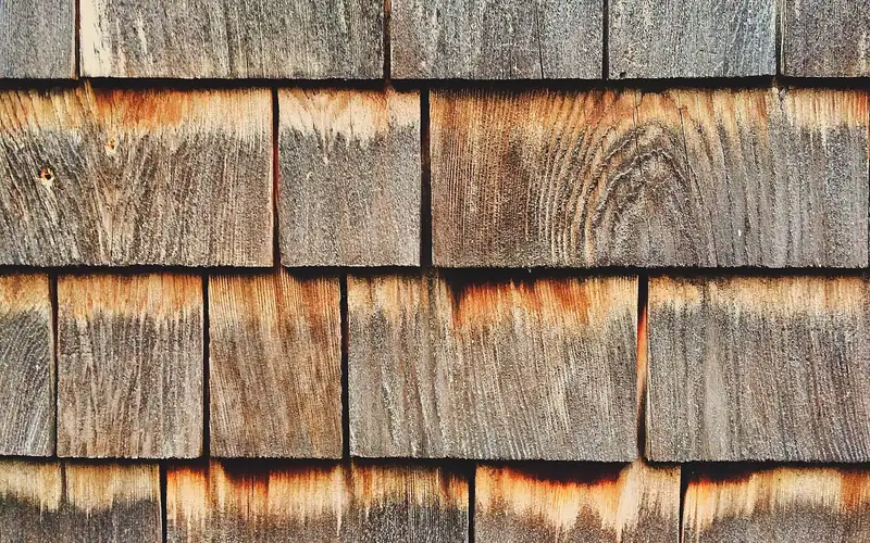weathered cedar shingles showing natural grain and slight gaps between courses