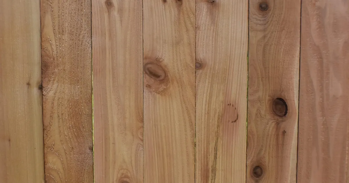 Reddish cedar fence boards with natural knots and grain