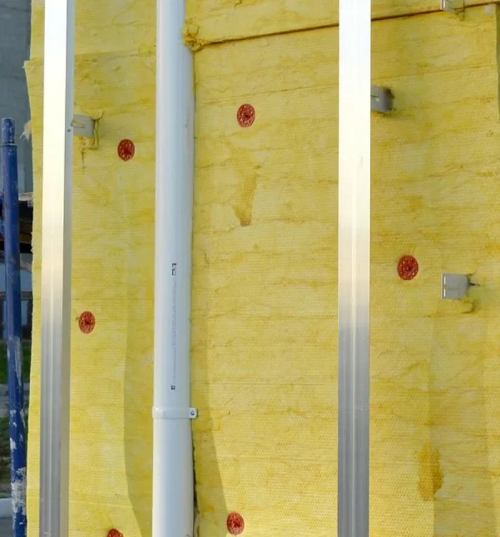 Rigid insulation boards fastened over an exterior wall with metal furring strips