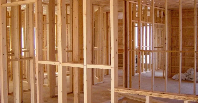 Wood-framed house walls under construction with studs and sheathing