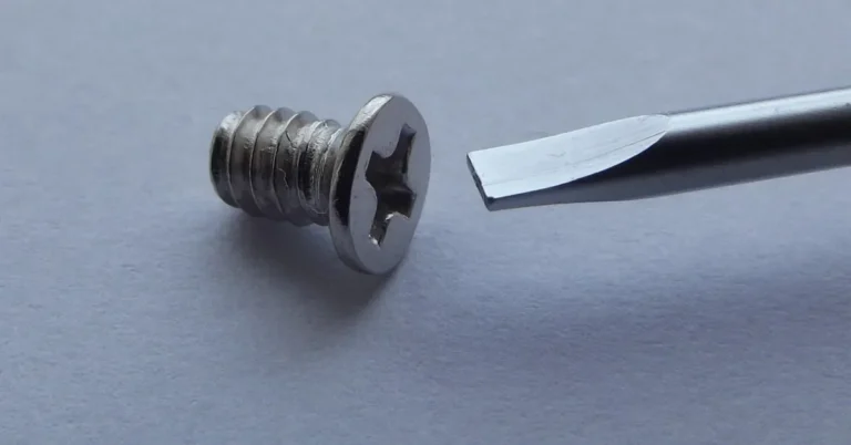 Phillips-head screw next to a flat screwdriver tip that does not fit the drive
