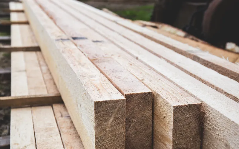 Stack of rough-sawn lumber boards stacked outdoors at a yard
