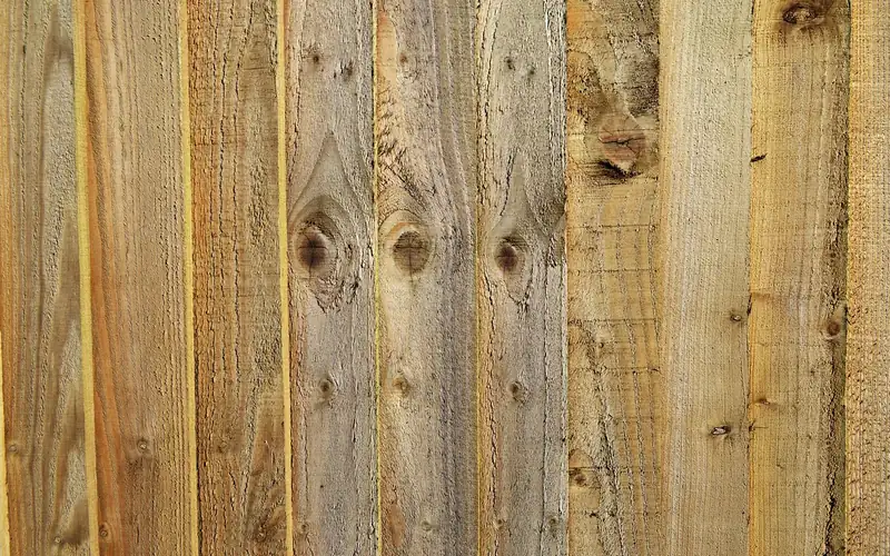 stacked unfinished cedar lumber boards used for fence material