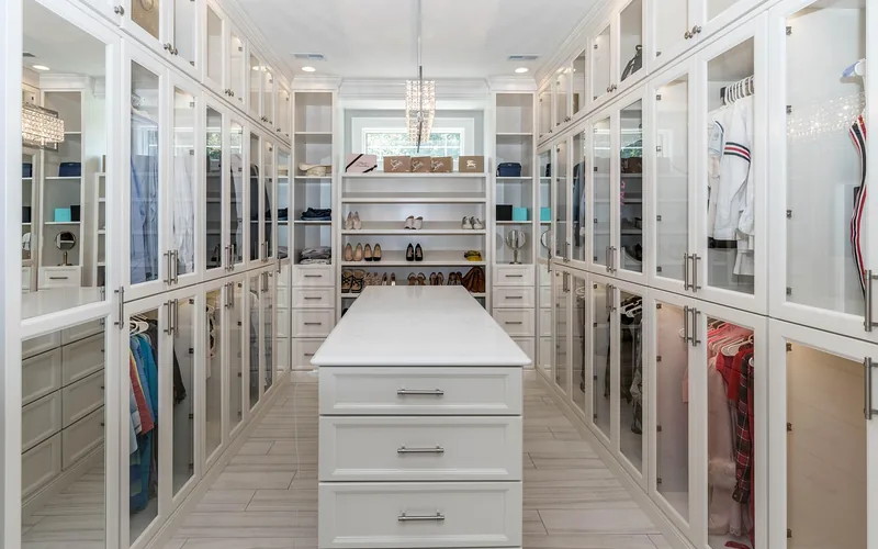 Walk-in closet with hanging clothes where cedar blocks are commonly placed for moth prevention