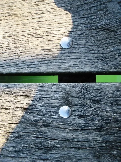 Weathered gray softwood deck boards with visible surface checking and metal fastener heads