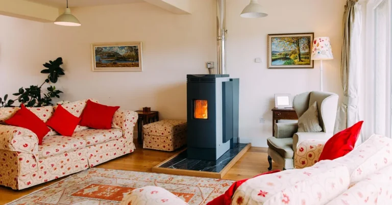 Freestanding wood burning stove with lit fire in a small living room corner