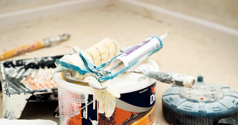 Caulking gun and tube among home renovation tools for a can-you-stain-caulk project