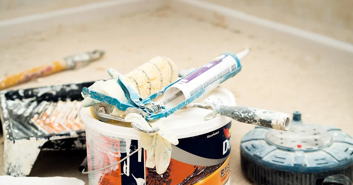 Caulking gun and tube among home renovation tools for a can-you-stain-caulk project