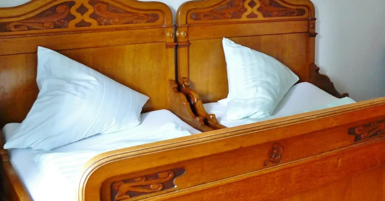 Carved wooden headboard on an Indian teak wood bed frame