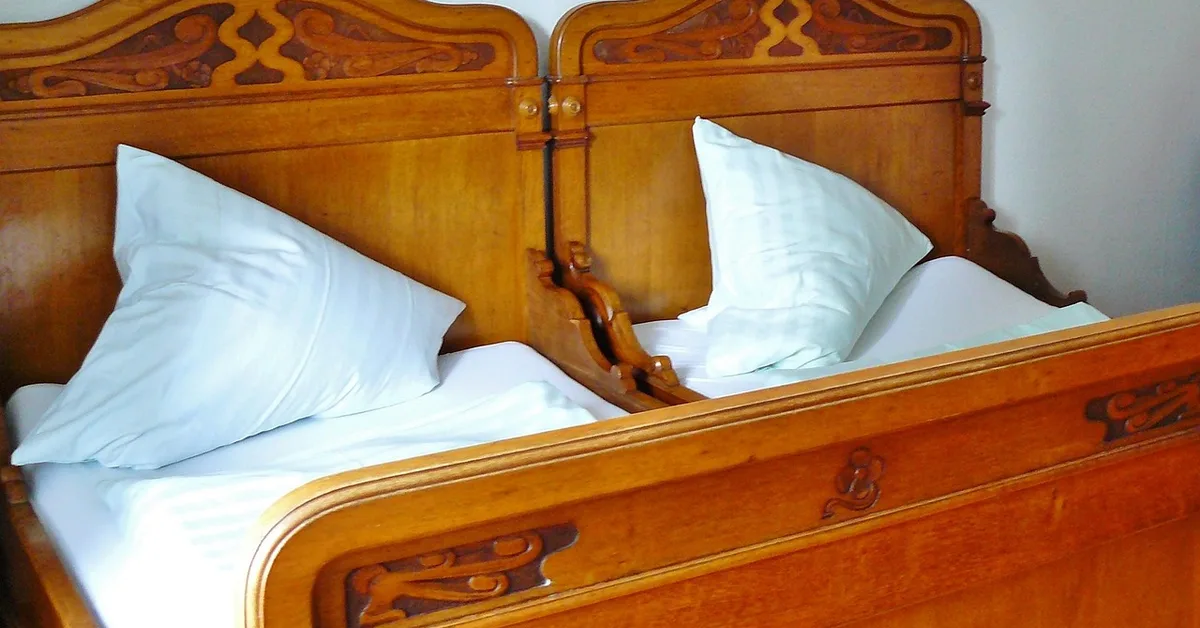 Carved wooden headboard on an Indian teak wood bed frame